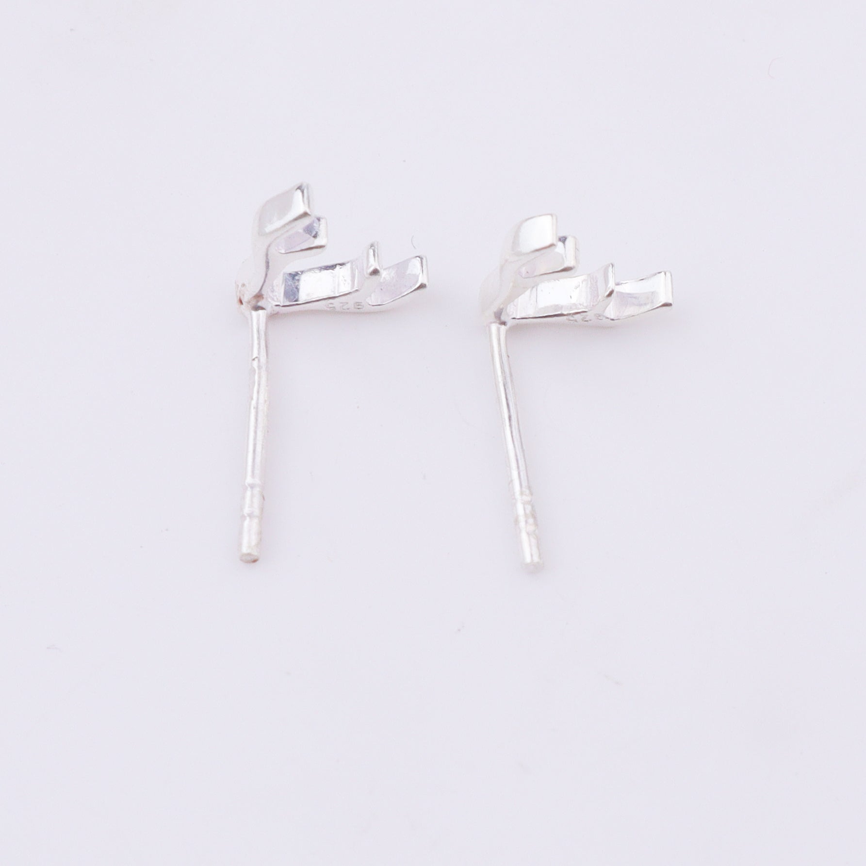 Silver deer horn studs earrings on white background