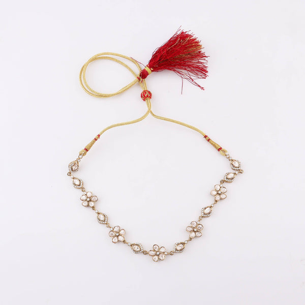 Detailed view of a brass fashion necklace highlighting intricate motifs, textured surface, and refined brass finish