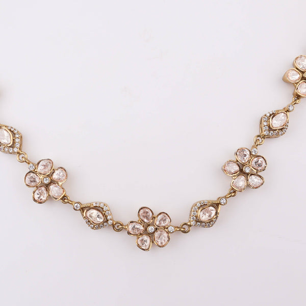 Angled view of a brass fashion necklace highlighting its unique silhouette, structure, and polished brass finish