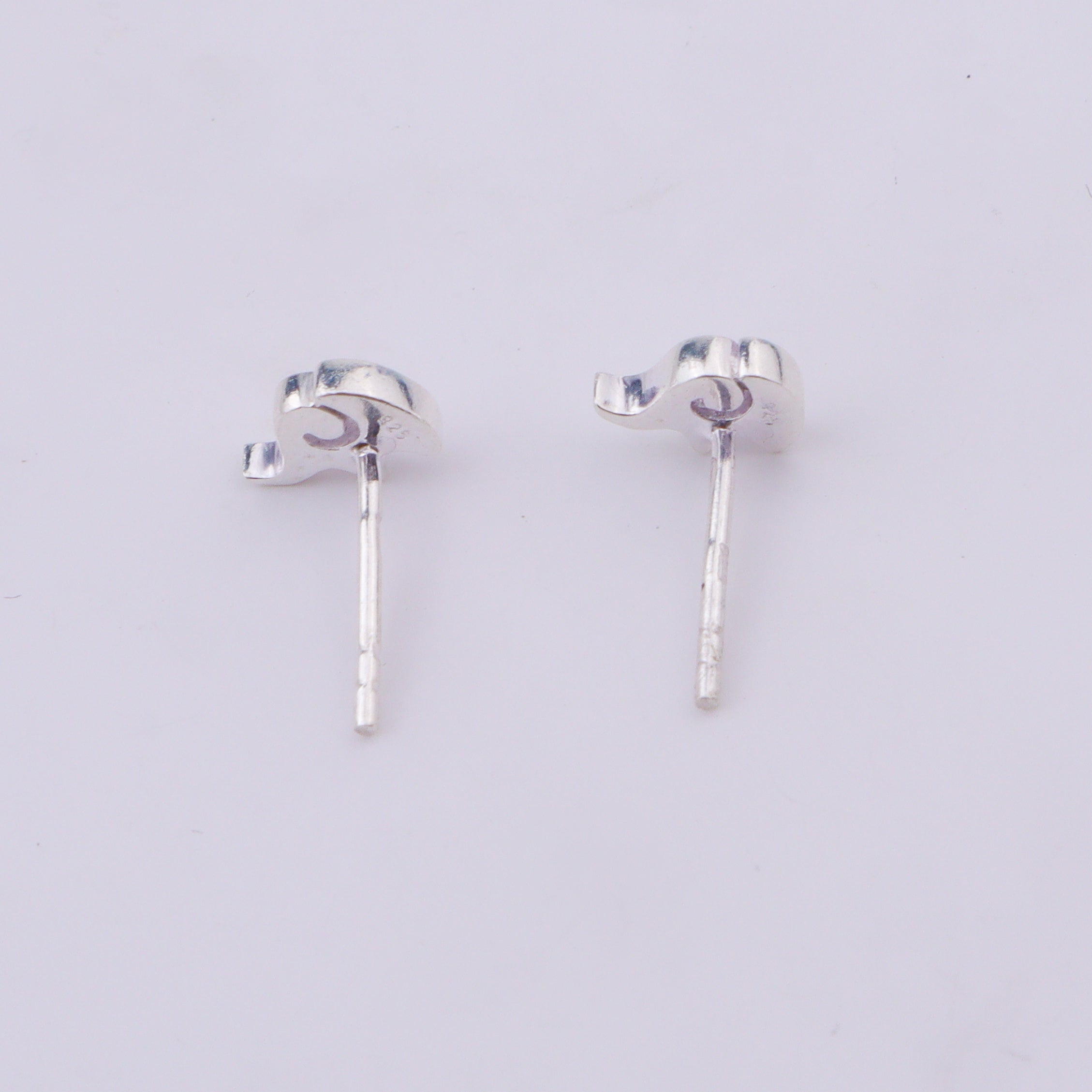 Silver elephant stud earrings on white surface