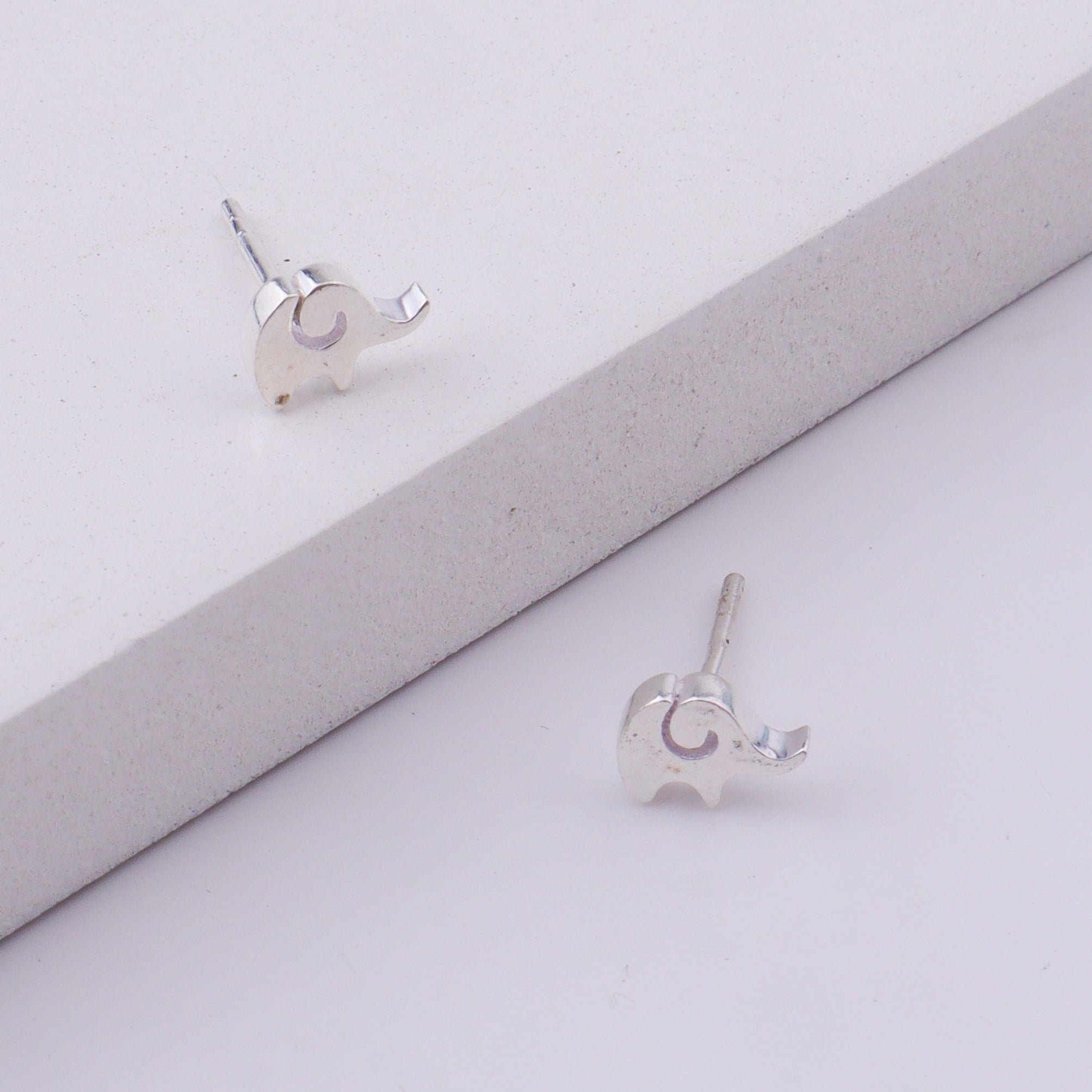 Close-up of silver elephant stud earrings on display