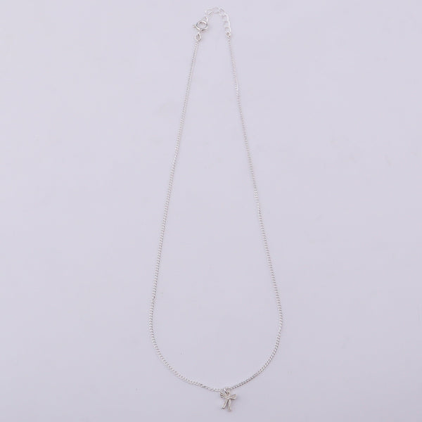 Silver necklace with bow pendant on white background