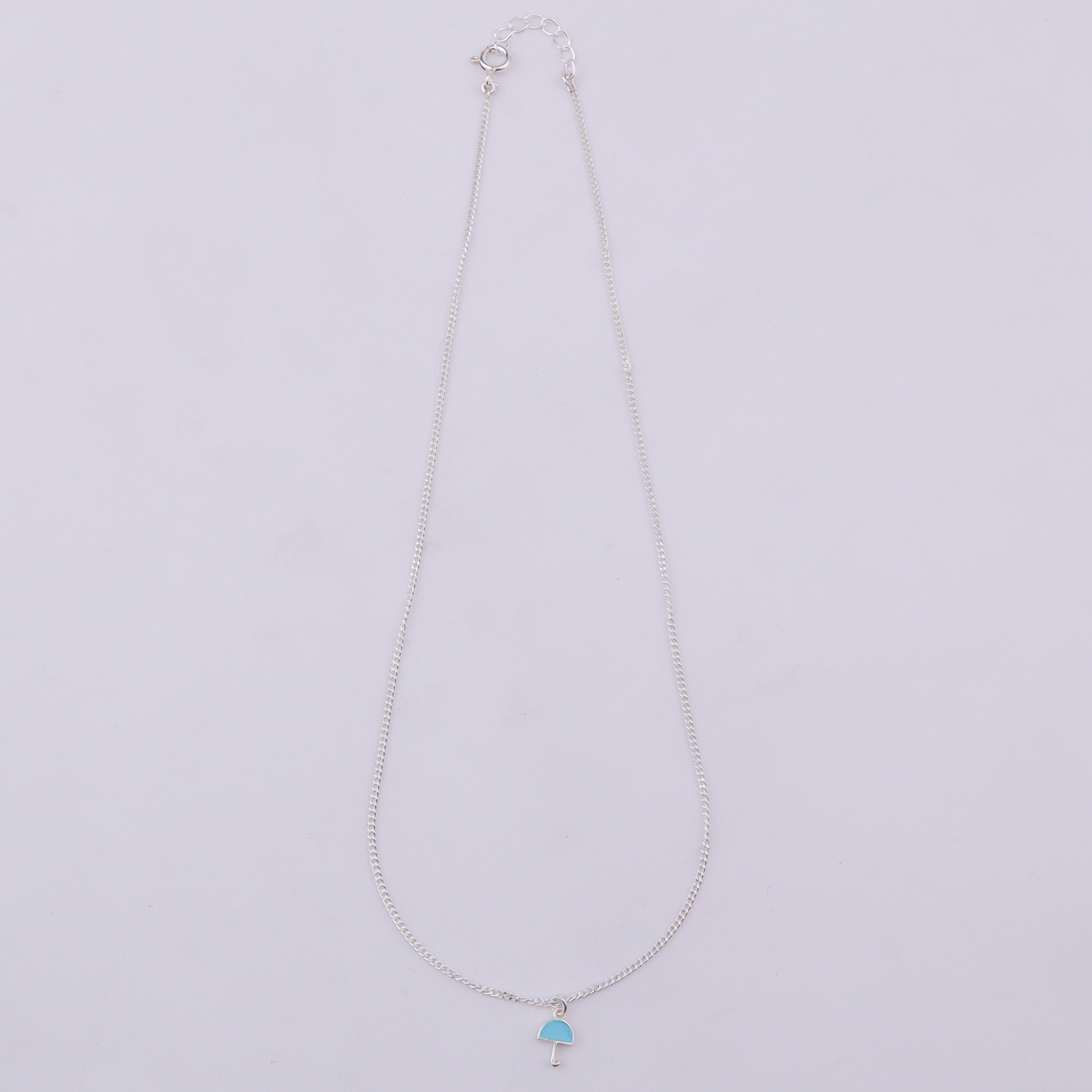 Close-up of silver umbrella pendant necklace with chain