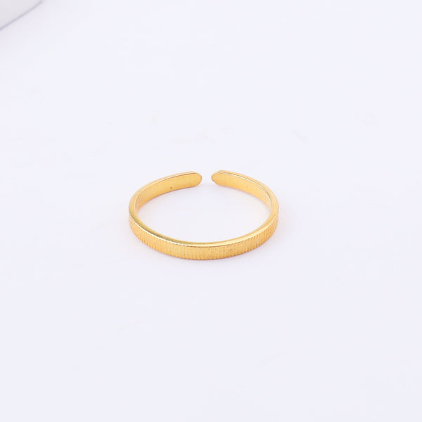 Gold textured open cuff bracelet on white surface