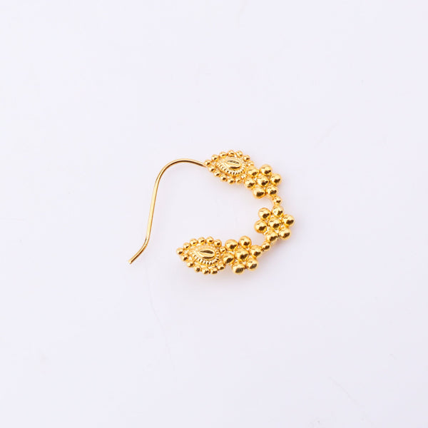 Close-up of gold nose ring on skin emphasizing craftsmanship
