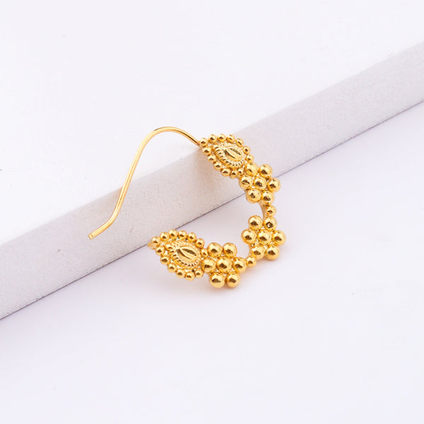 Gold nose ring displayed on white background for jewelry showcase
