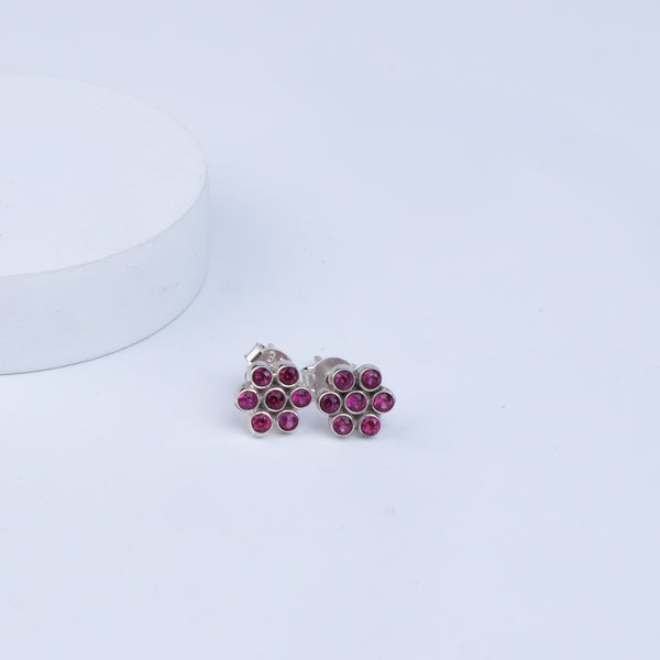 Silver Zircon Pink Kudi earrings with pink gemstones on white surface