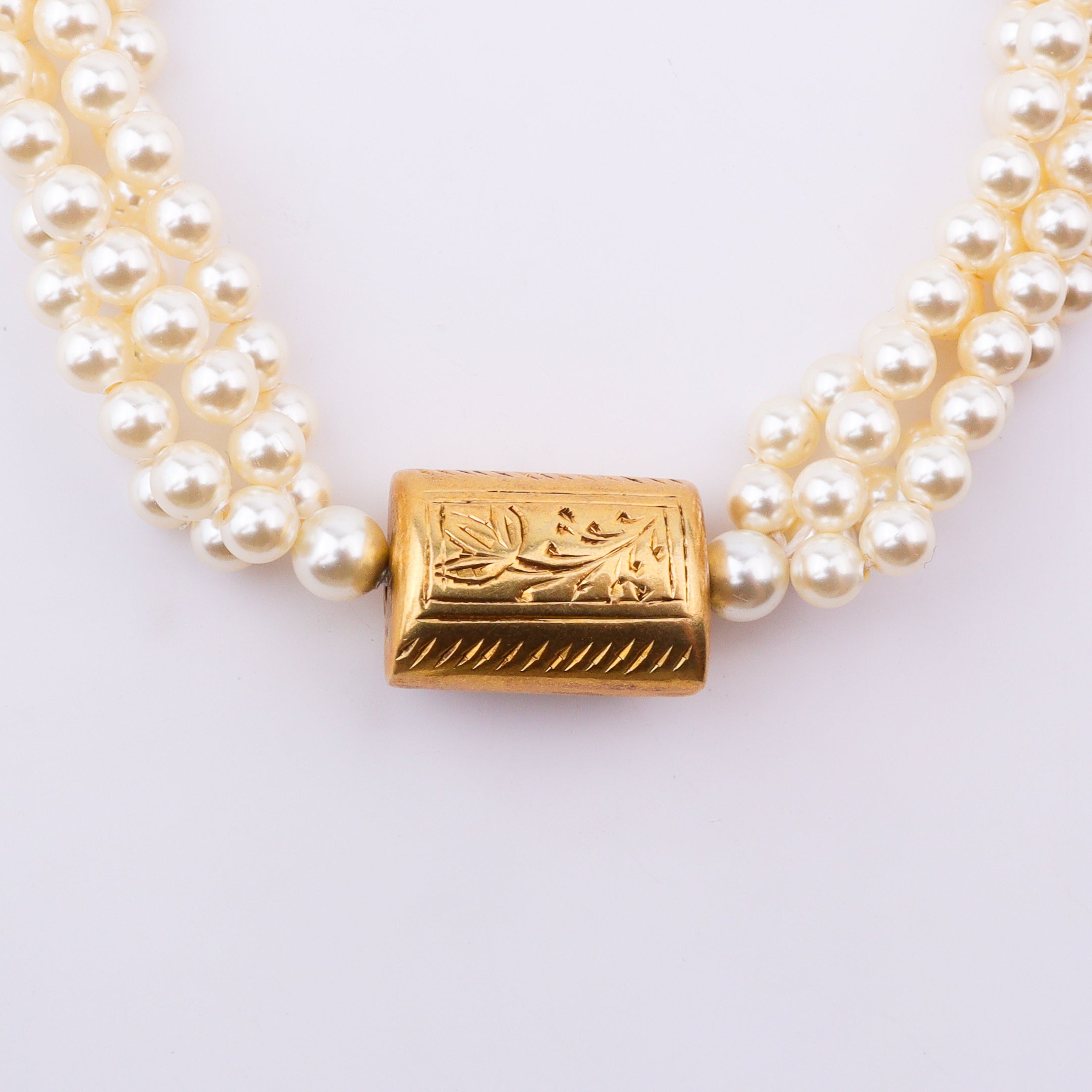 Pearl necklace with gold clasp and carved bead detail