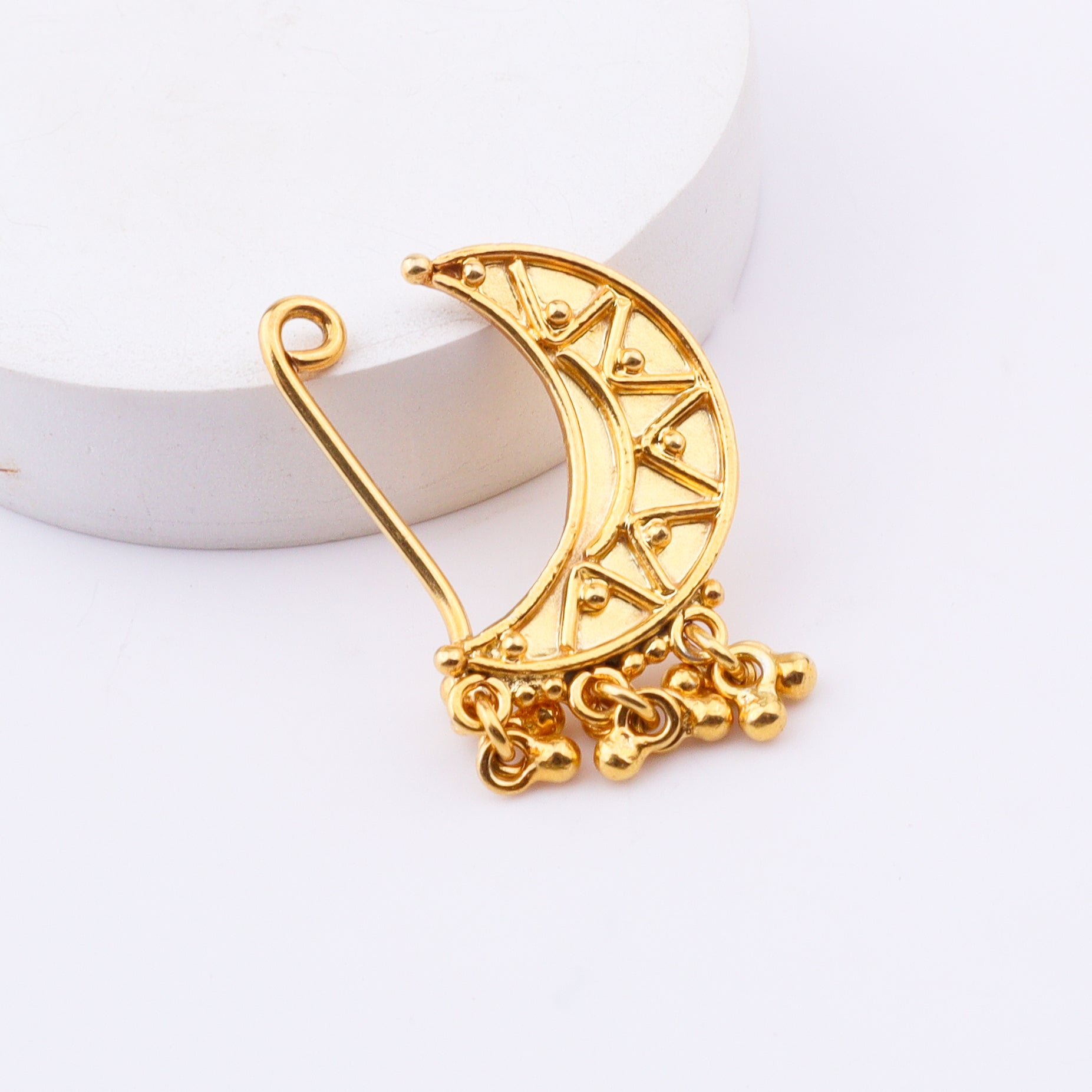 Gold crescent moon earring on white background