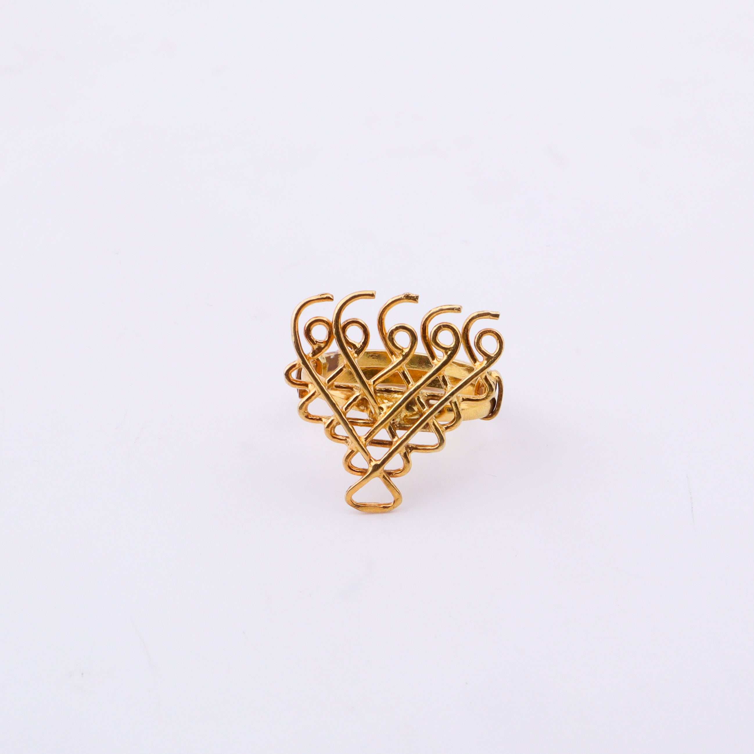 Bottom view of gold plated Saraswati ring on white surface