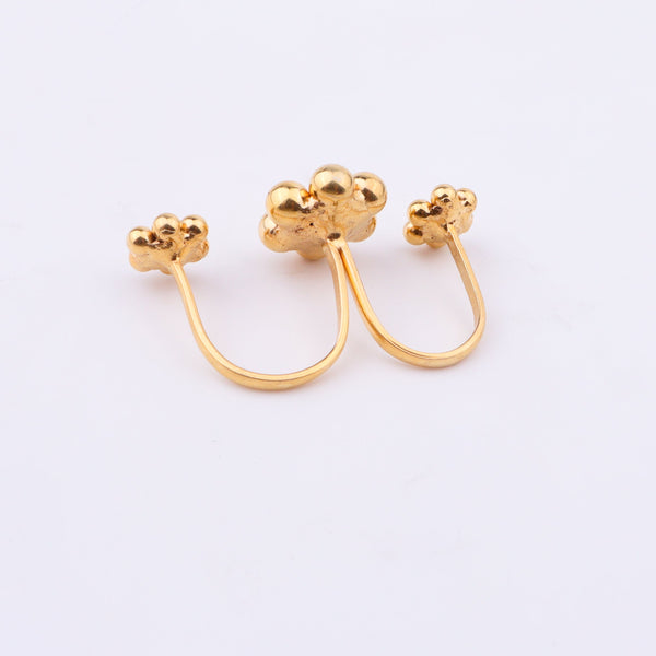Gold plated floral cluster ring on white surface