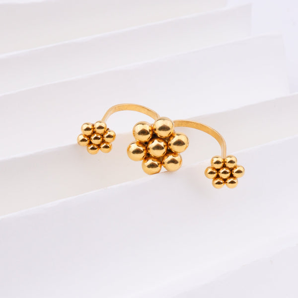 Gold plated floral cluster ring on white background