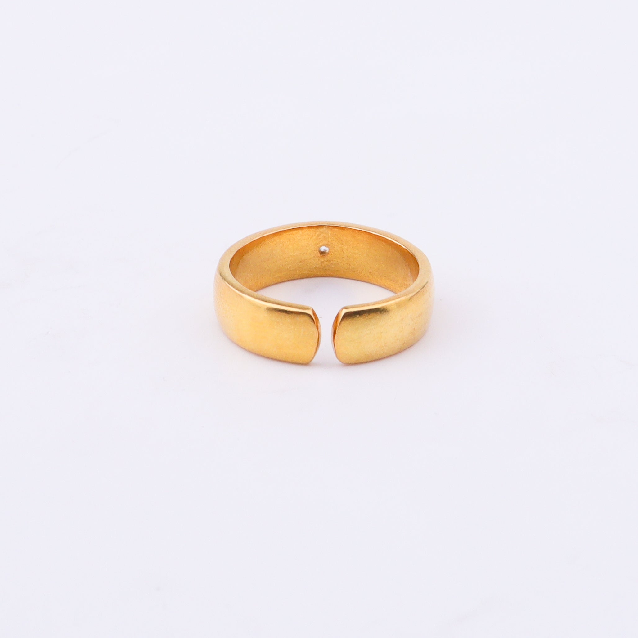 Gold ring with diamond on white surface