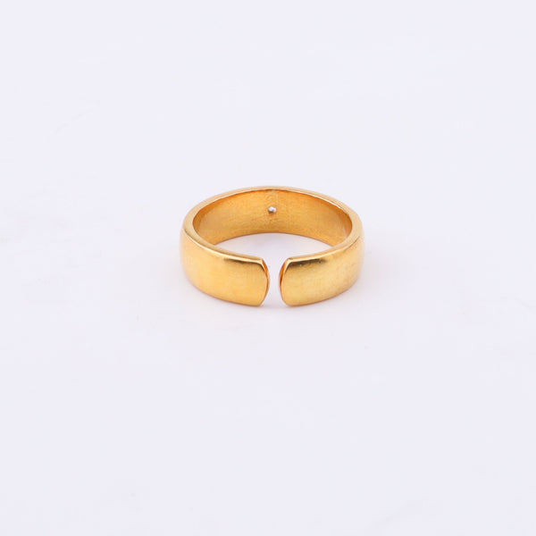 Gold ring with diamond on white surface