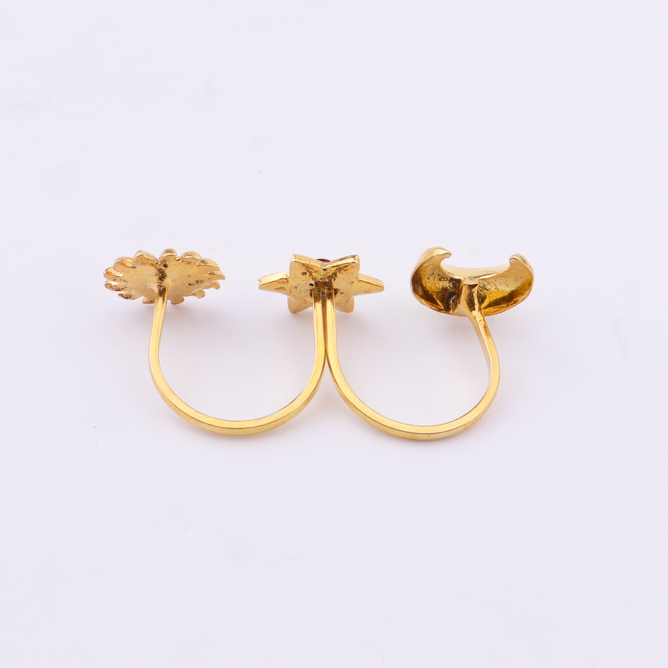 Gold moon and star rings with red gemstones on hand