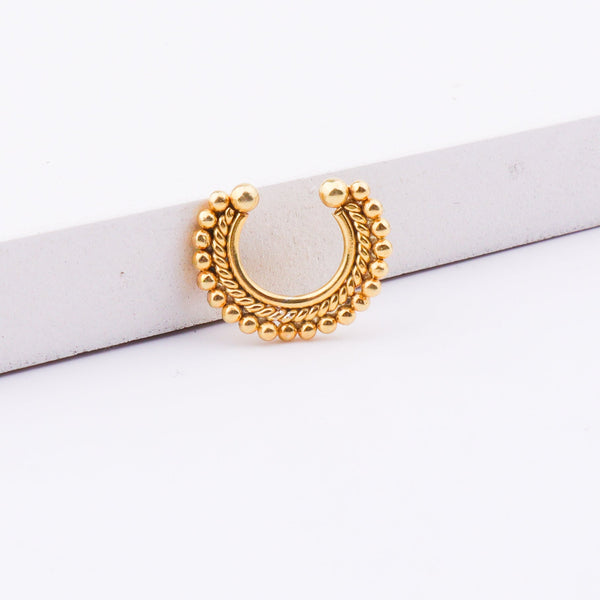 Gold nose ring on white background