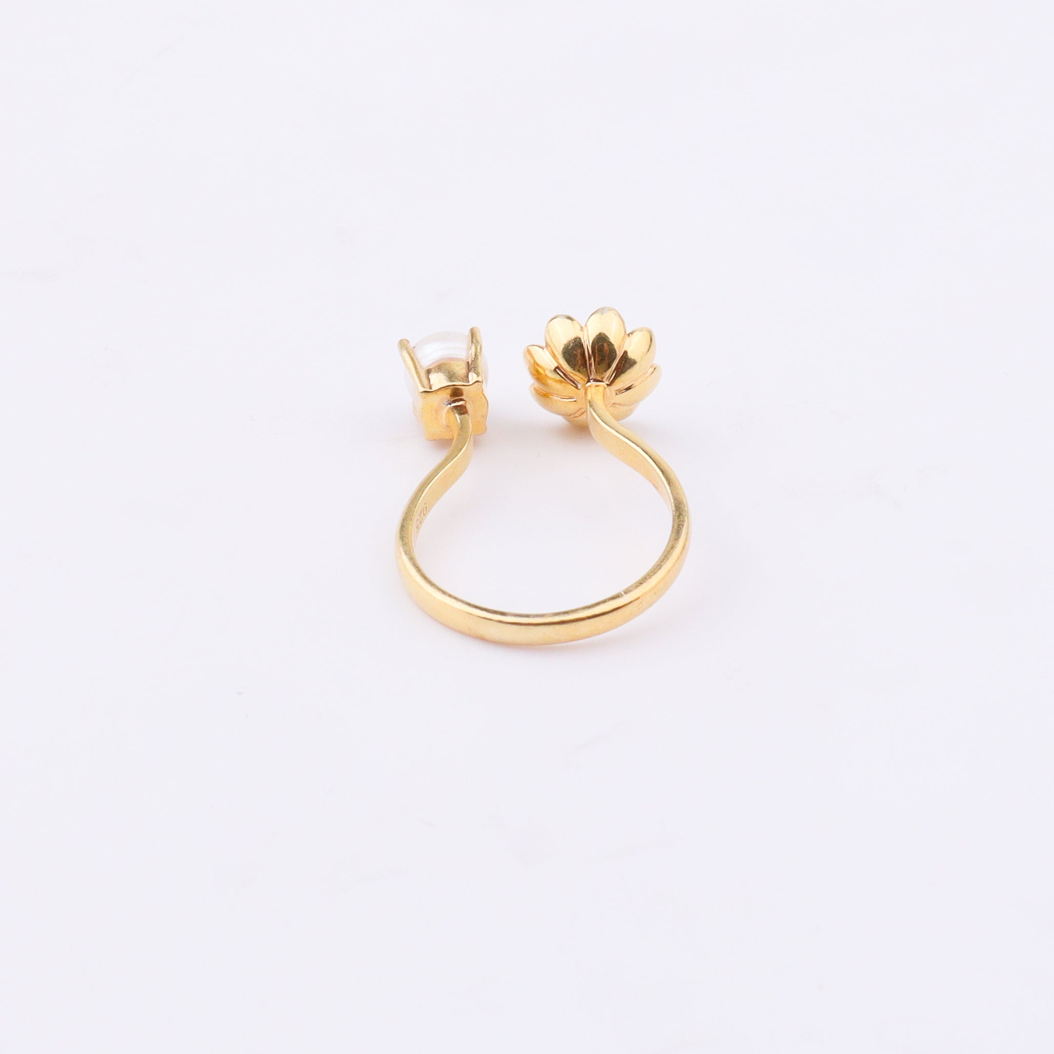 Gold floral ring with pearl on white background