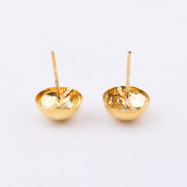 Gold earrings with white backdrop and shadow