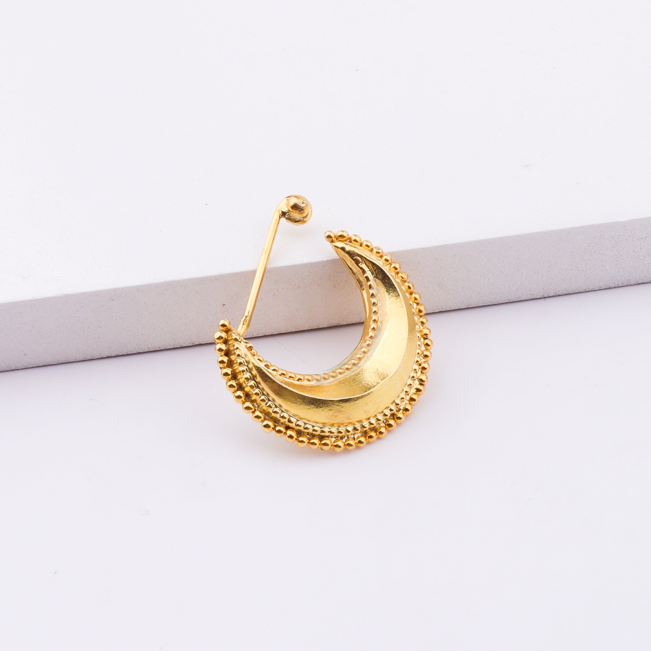 Model wearing gold crescent moon body jewelry with earrings