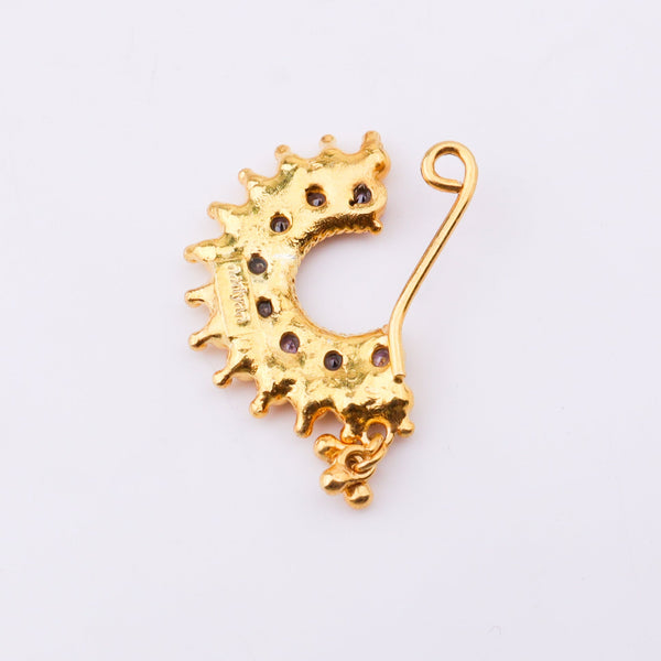 Gold nose pin with purple gemstones on white background