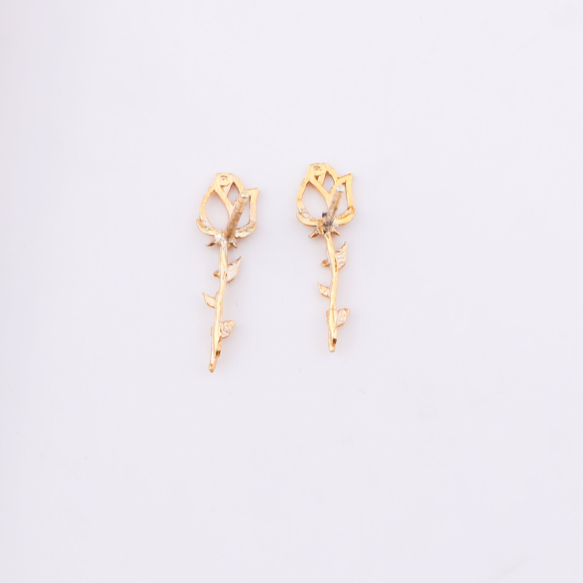 Gold floral stud earrings on white background