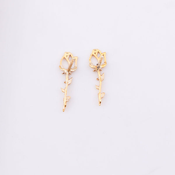 Gold floral stud earrings on white background