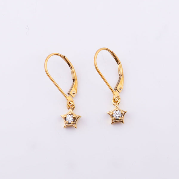 Gold star earrings with cubic zirconia stones on white surface