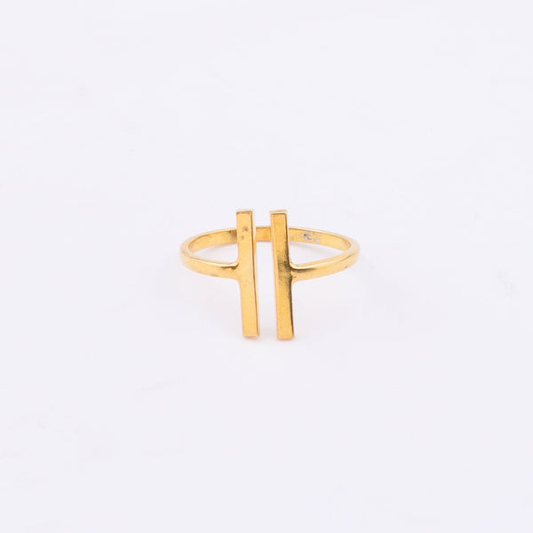 Gold ring with H-shaped design on white background