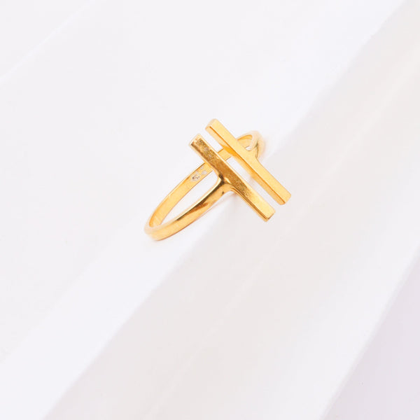 Gold ring with H-shaped design on white background