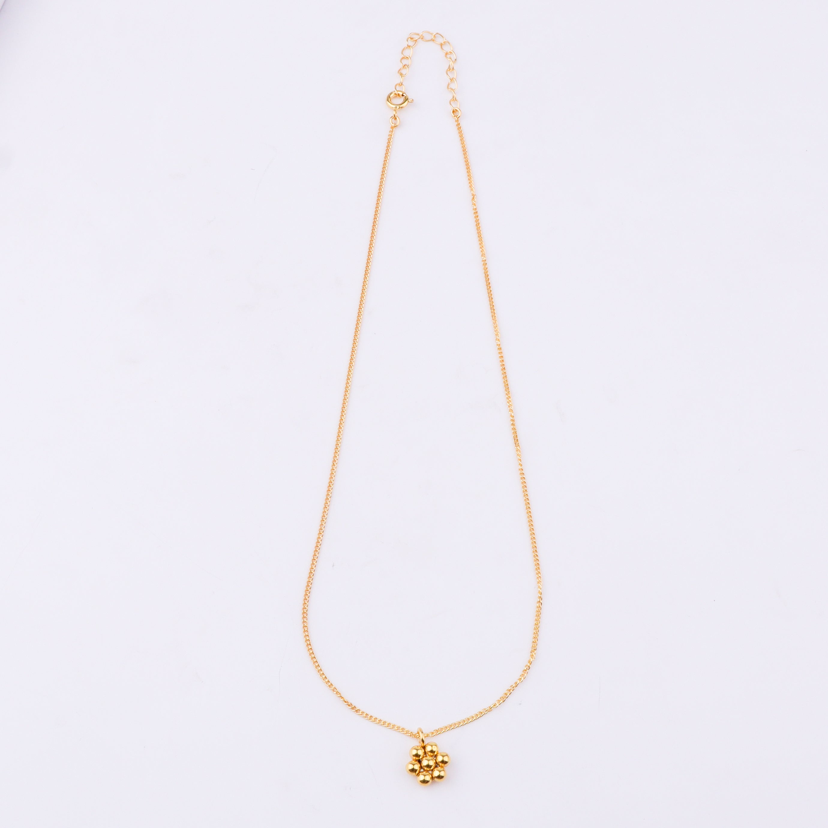 Close-up of gold chain with spherical pendant