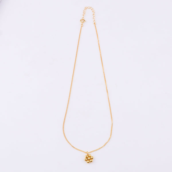 Close-up of gold chain with spherical pendant