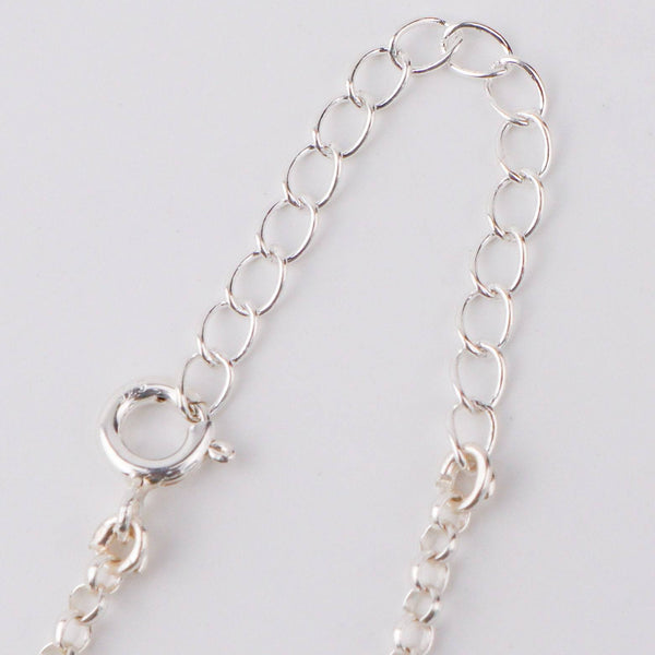 Woman styling 92.5 silver moon phase necklace with casual or contemporary outfit