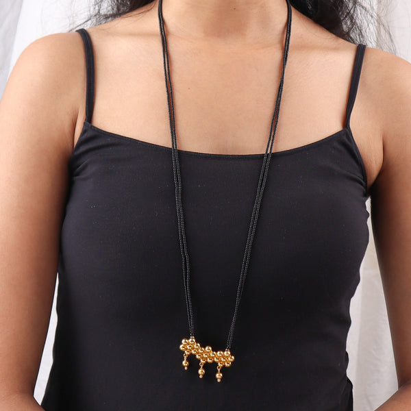 Close-up of black beaded necklace on white background