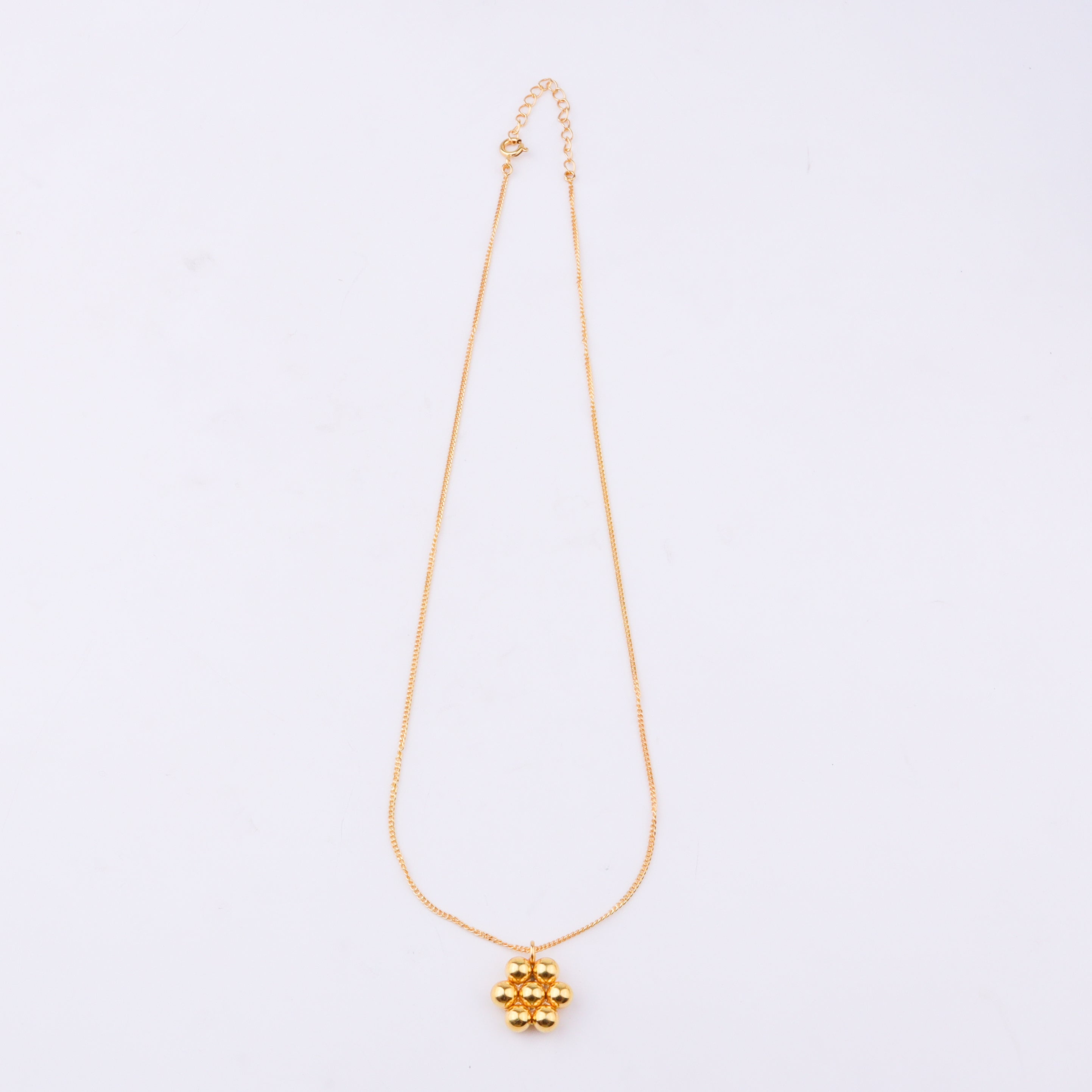 Gold chain necklace displayed on white jewelry stand