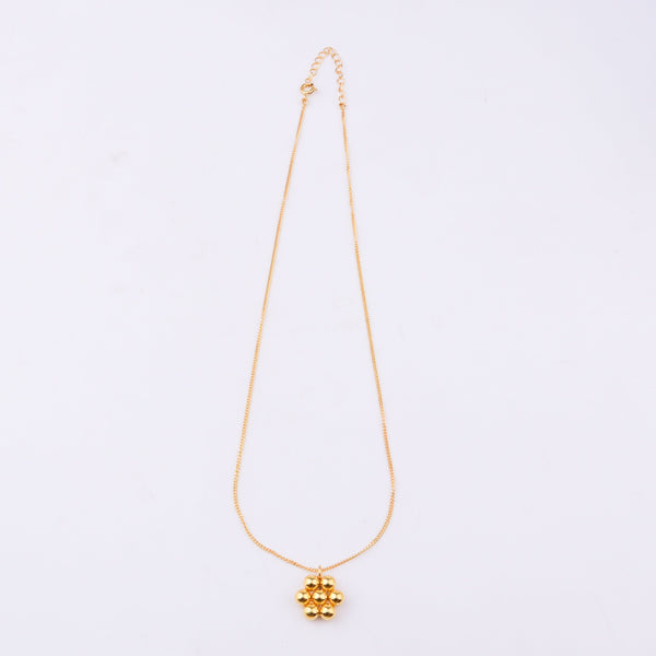 Gold chain necklace displayed on white jewelry stand