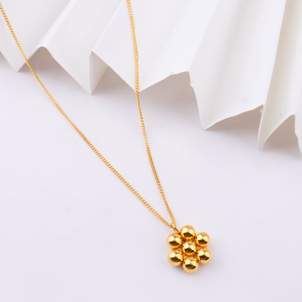 Gold chain with circular links on white surface