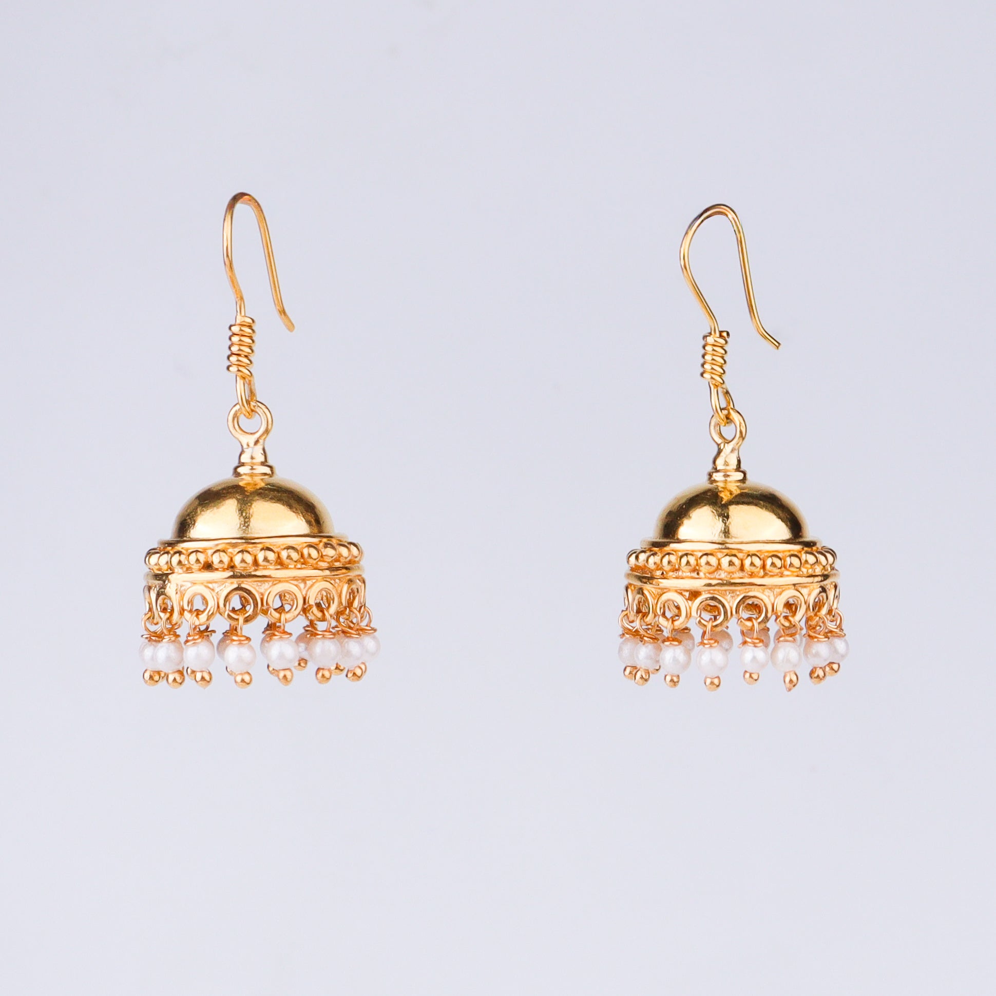 Gold earrings with pearl drops and detailed craftsmanship