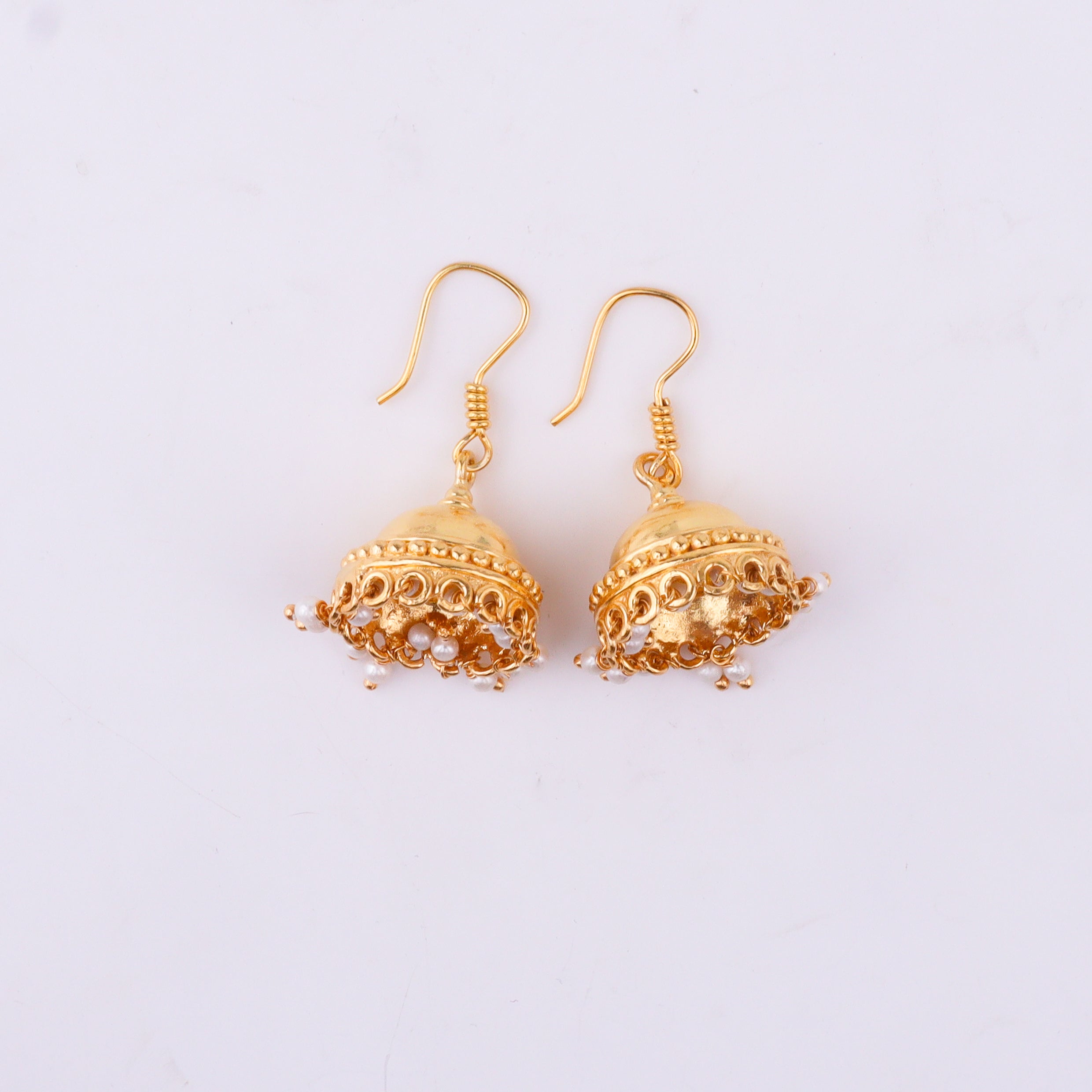 Gold earrings with intricate design and pearl drops