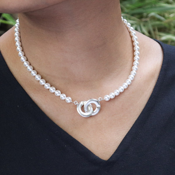 Model wearing pearl necklace with silver clasp
