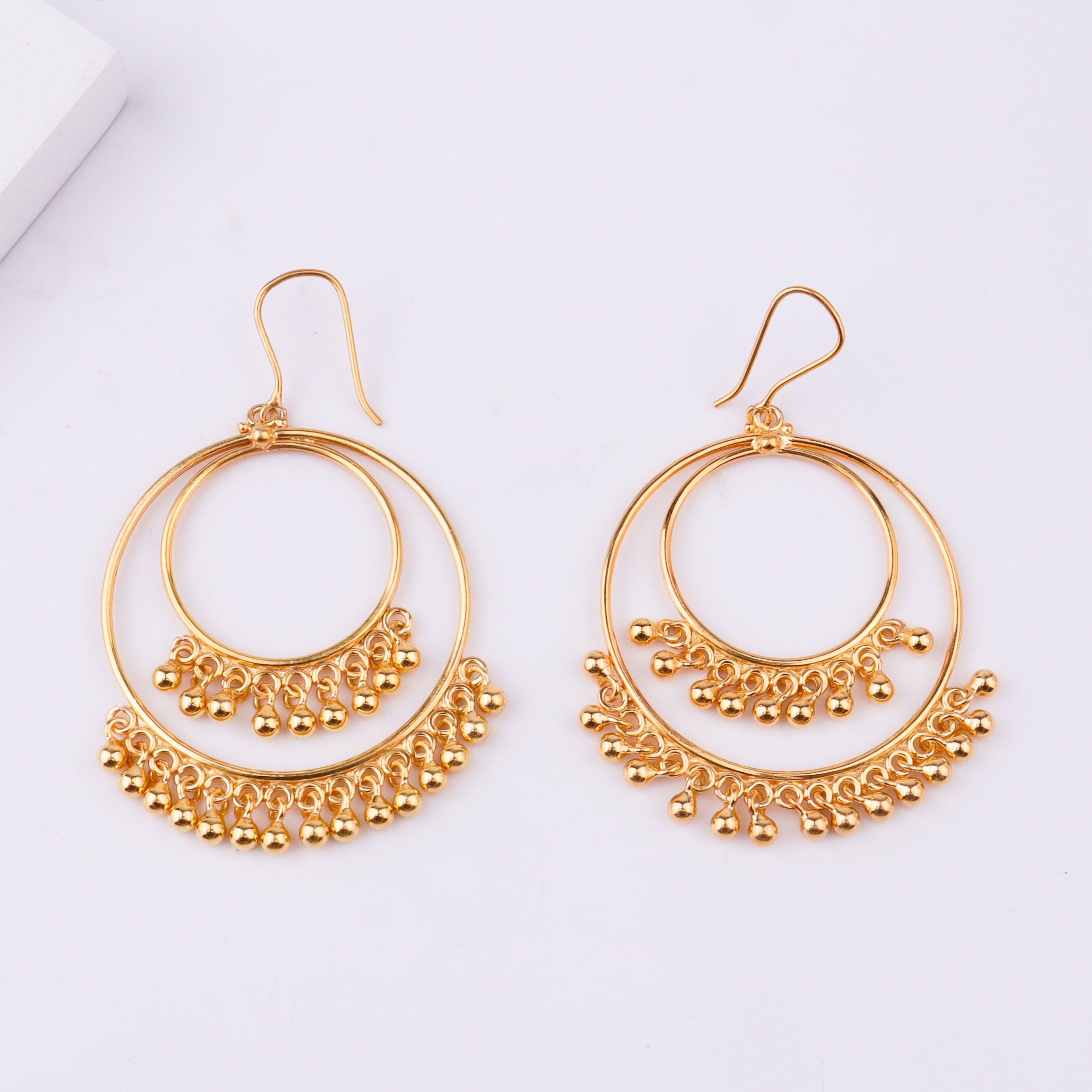 Gold earrings on white background