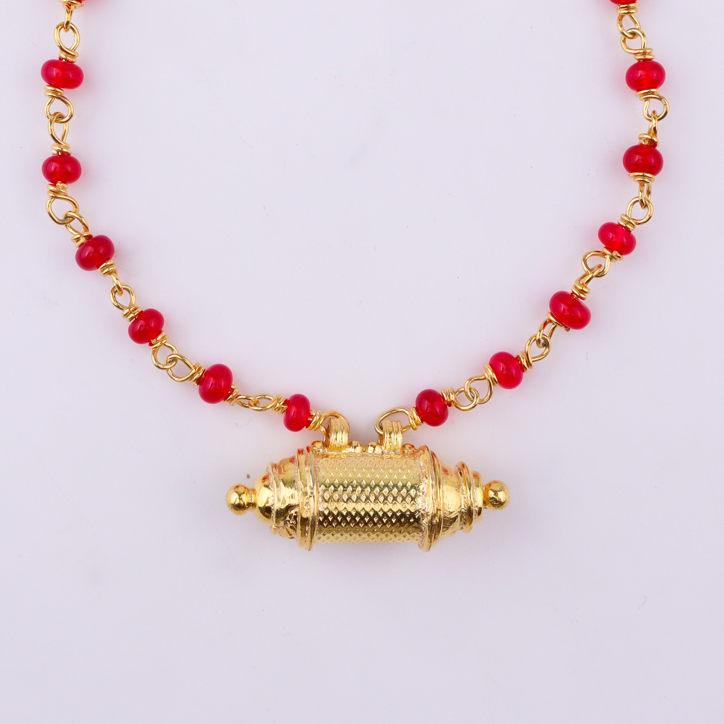 Elegant gold necklace with red beads and pendant