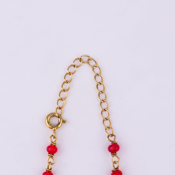 Gold chain with red beads