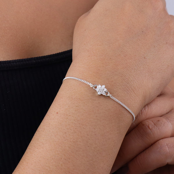 Silver bracelet with floral charm on wrist