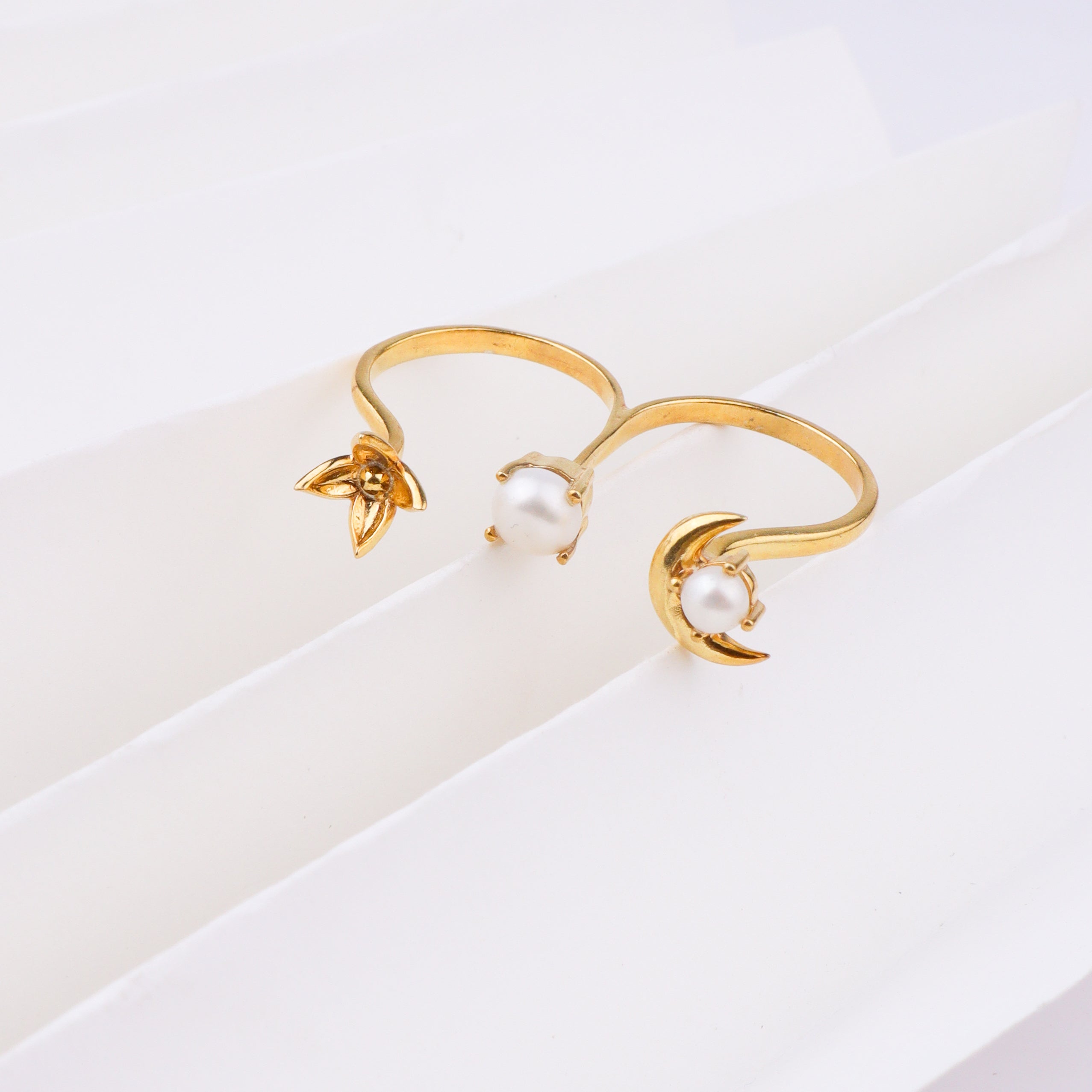 Gold moon and pearl ring on white background