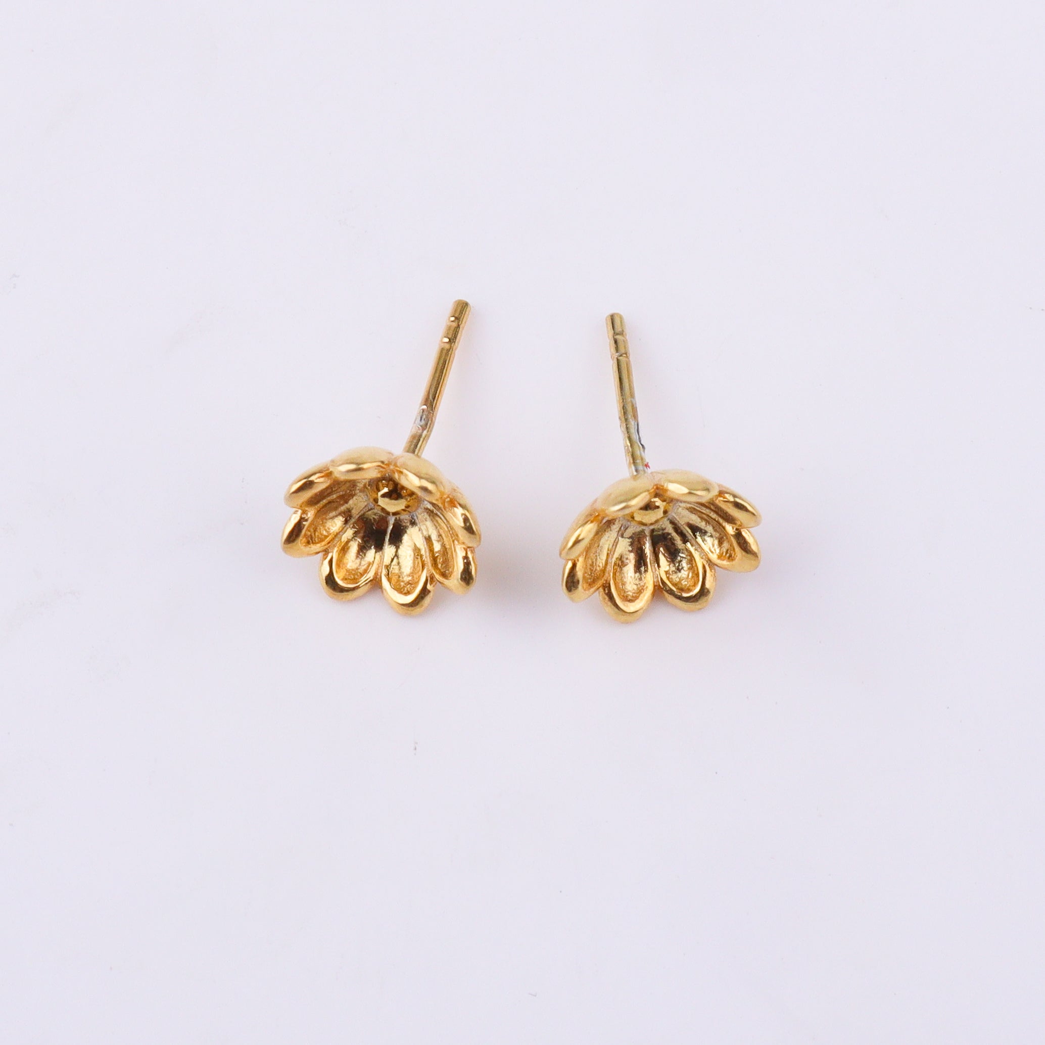 Earrings on white surface with reflection