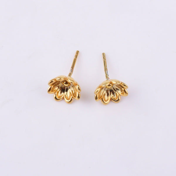 Earrings on white surface with reflection