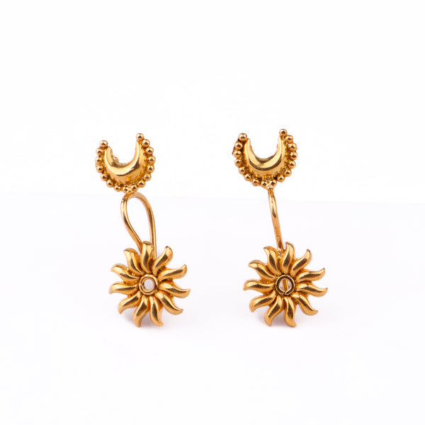 Gold moon earrings with floral design on white surface