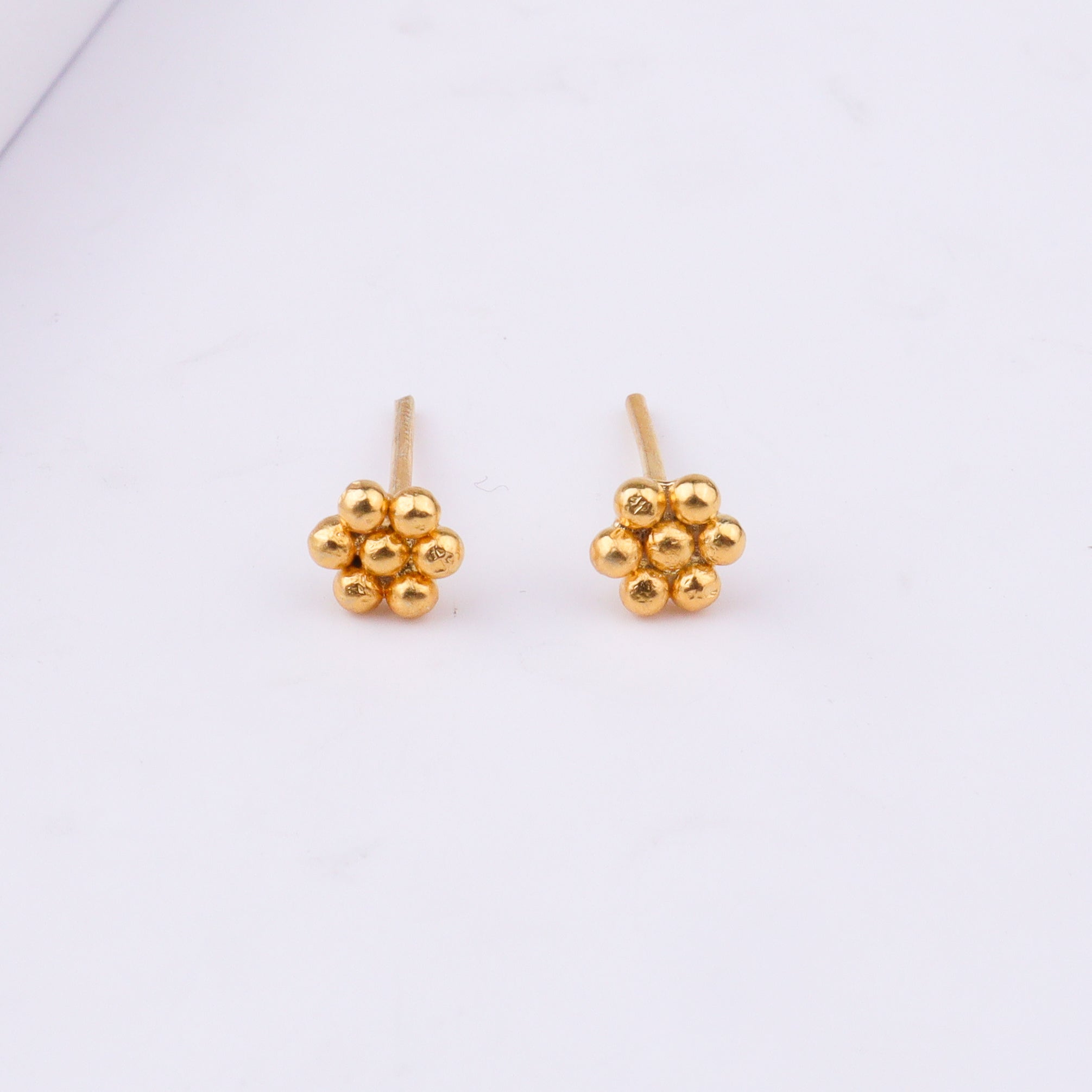Gold earrings on white background