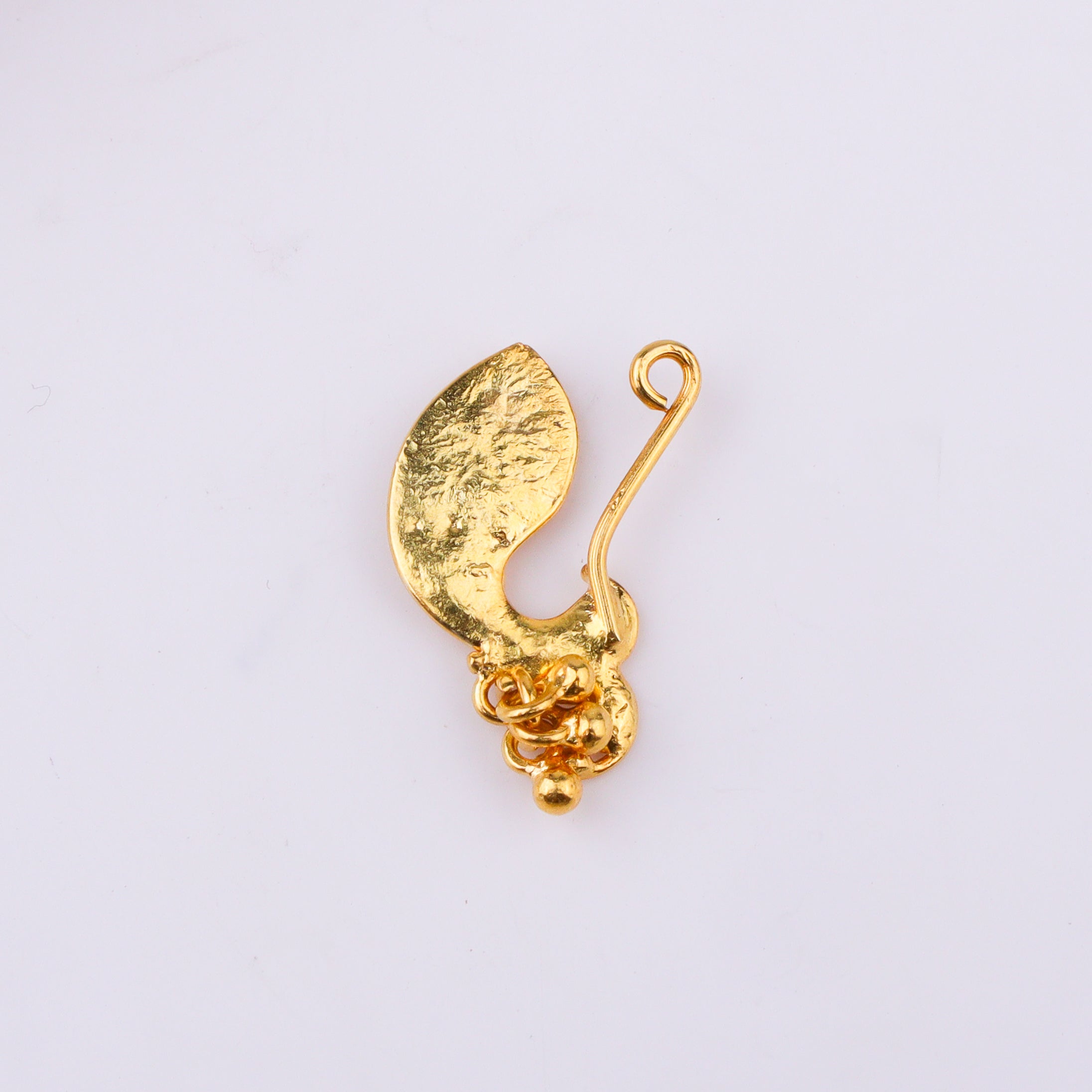 White background with gold nose ring and chain jewelry close-up