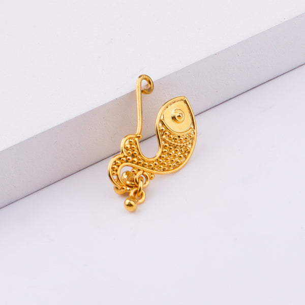 Model wearing gold nose ring with eye makeup and nose piercing